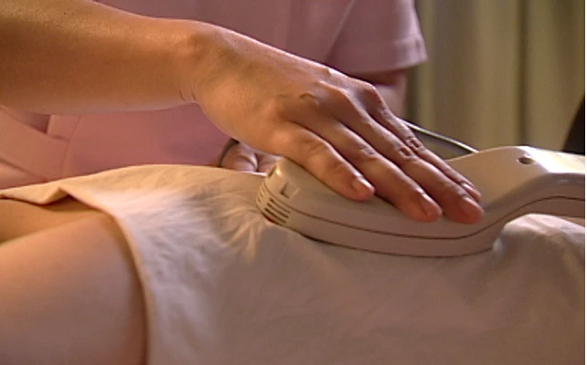 琉球温熱療法の施術風景。女性の腰を集中的に温めている様子