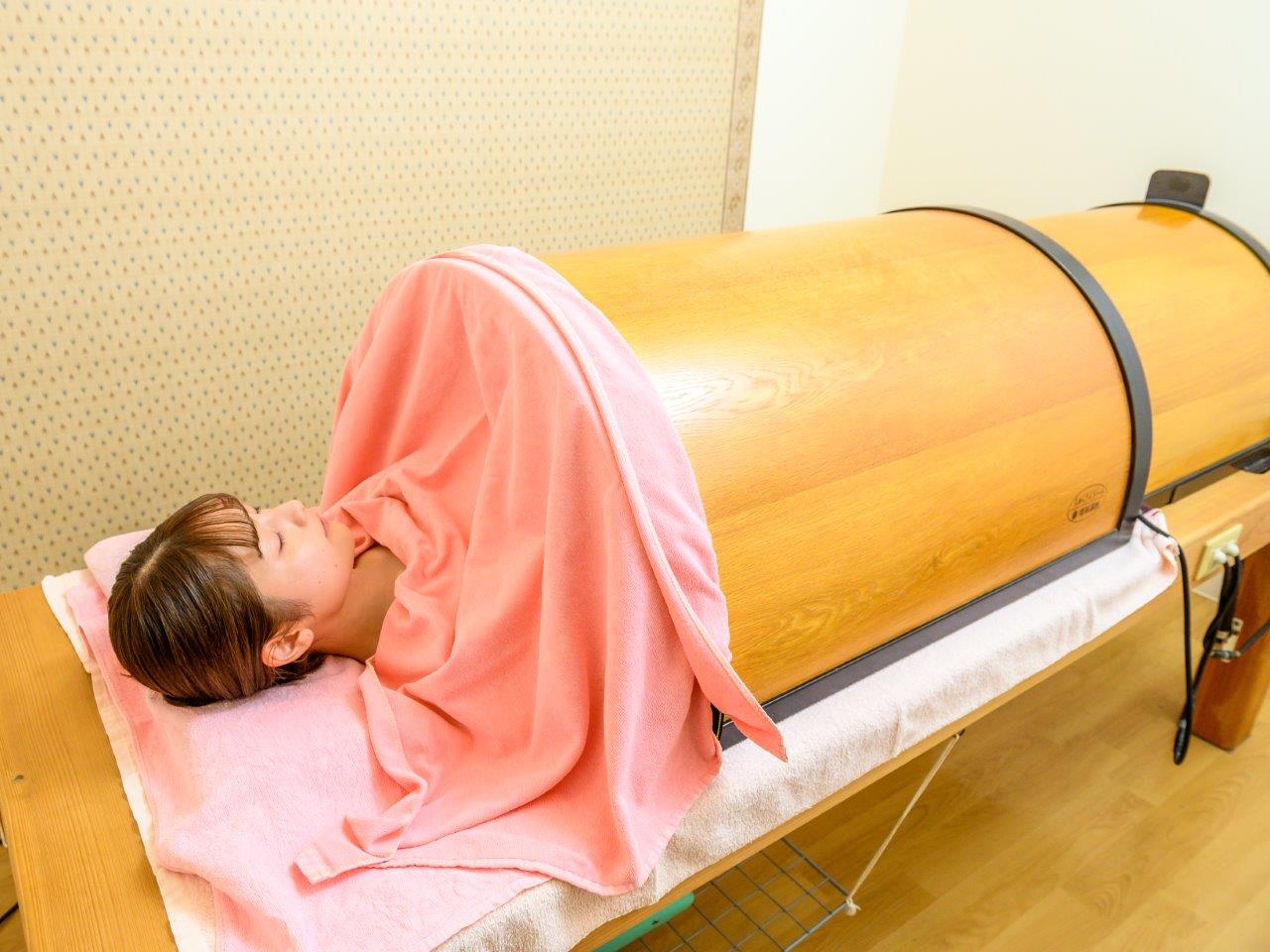 温熱ドームベッドに入ってリラックスしながら汗をかいているお客様